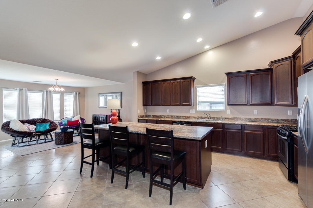 17776 West Charter Oak Road Surprise, AZ 85388 - Photo 14 of 35 a large dining hall with stainless steel appliances granite countertop a stove a sink a dining table and chairs