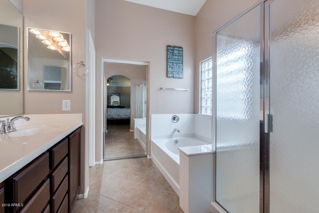 17776 West Charter Oak Road Surprise, AZ 85388 - Photo 21 of 35 a en suite bathroom with a sink tub and mirror