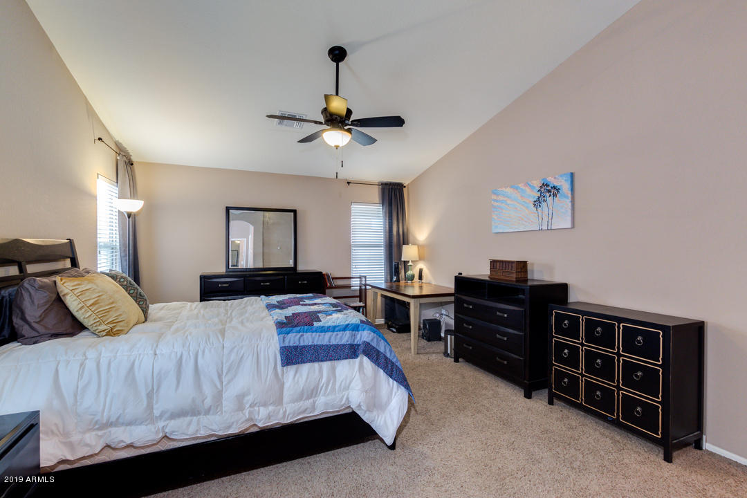 17776 West Charter Oak Road Surprise, AZ 85388 - Photo 33 of 35 a bedroom with a bed and a chandelier