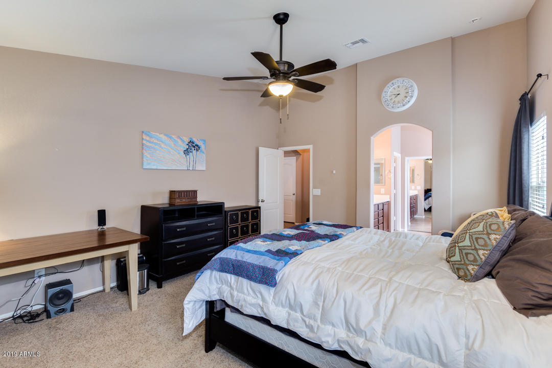 17776 West Charter Oak Road Surprise, AZ 85388 - Photo 34 of 35 a bedroom with a bed and a chandelier