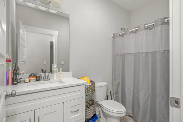 a bathroom with a sink a toilet and shower curtain