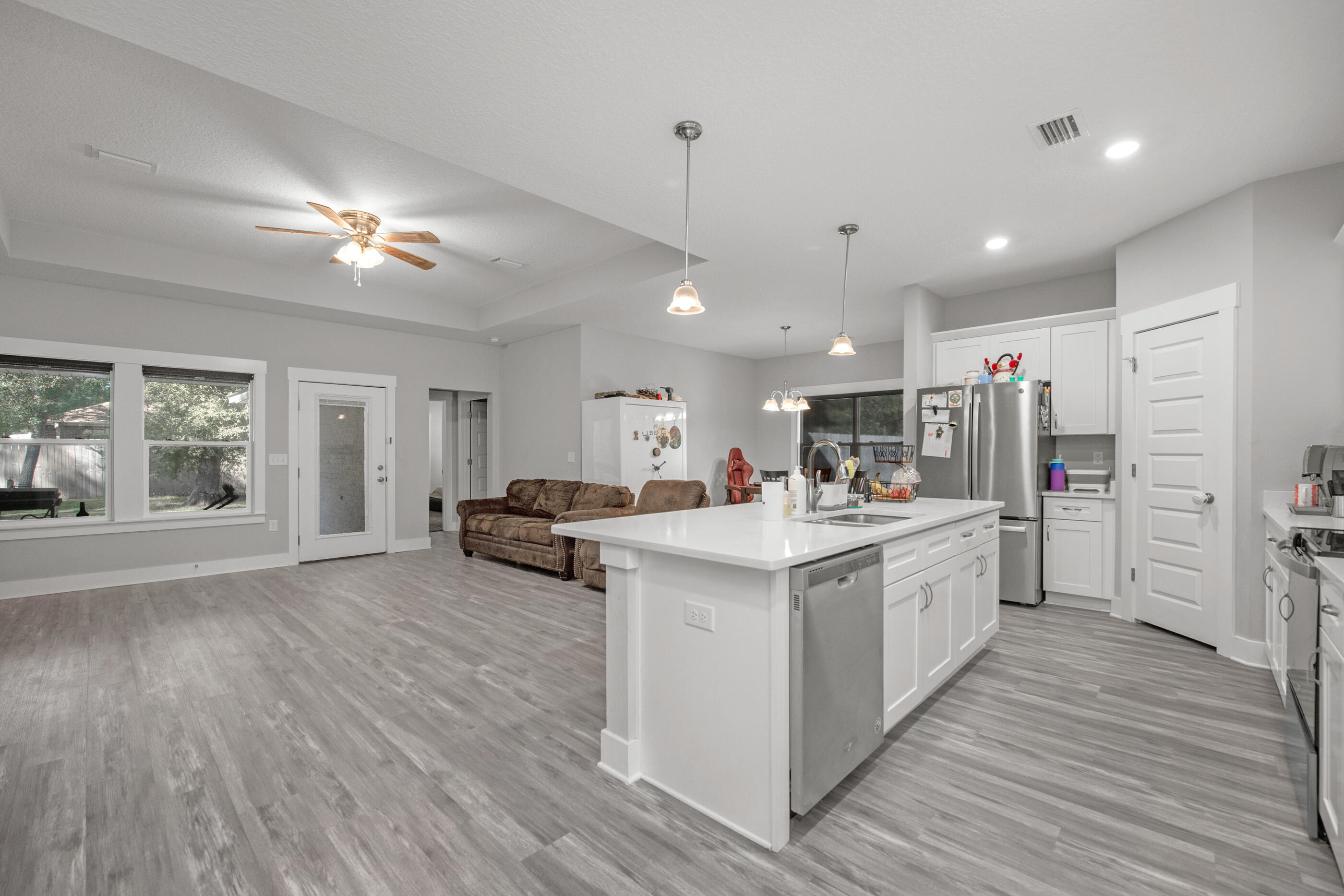 2800 Ram Lane Crestview, FL 32539 - Photo 6 of 24 a large kitchen with kitchen island a stove a refrigerator a sink dishwasher with a dining table and chairs with wooden floor