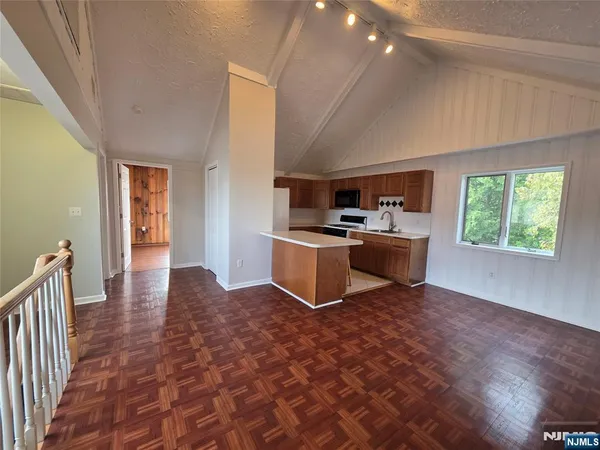 a kitchen with granite countertop a stove top oven and cabinets