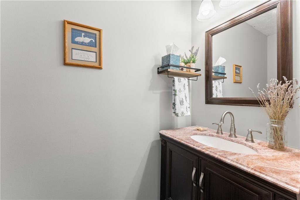 709 Muirfield Drive Winder, GA 30680 - Photo 14 of 65 a bathroom with a granite countertop sink a mirror and a