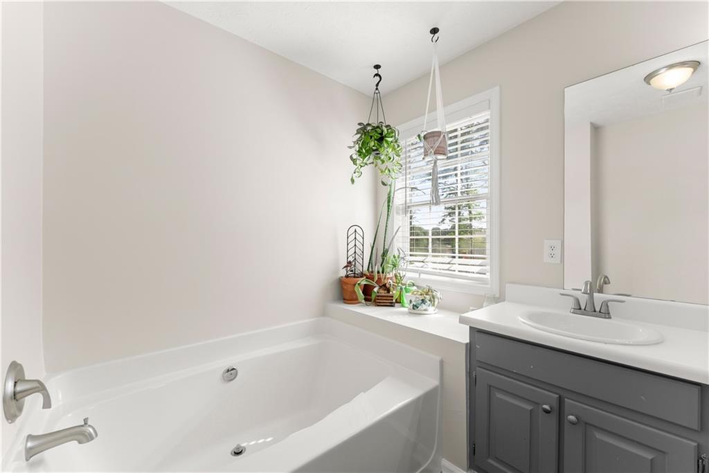 709 Muirfield Drive Winder, GA 30680 - Photo 31 of 65 a bathroom with a tub sink and mirror