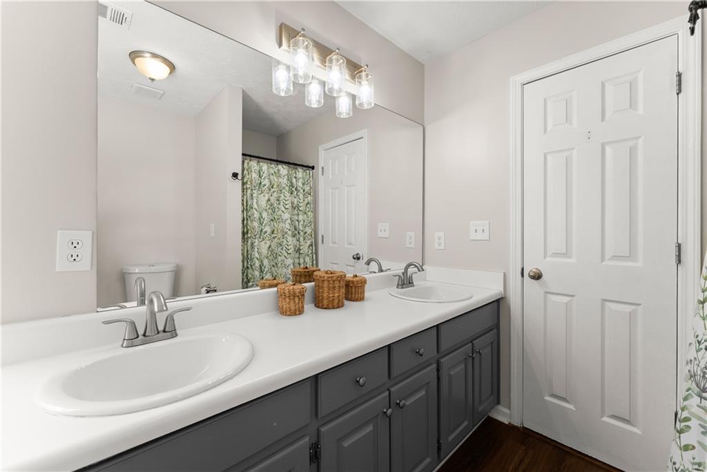 709 Muirfield Drive Winder, GA 30680 - Photo 33 of 65 a bathroom with a double vanity sink and a mirror