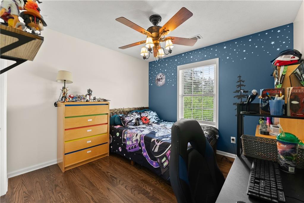 709 Muirfield Drive Winder, GA 30680 - Photo 34 of 65 a bedroom with a bed and wooden floor