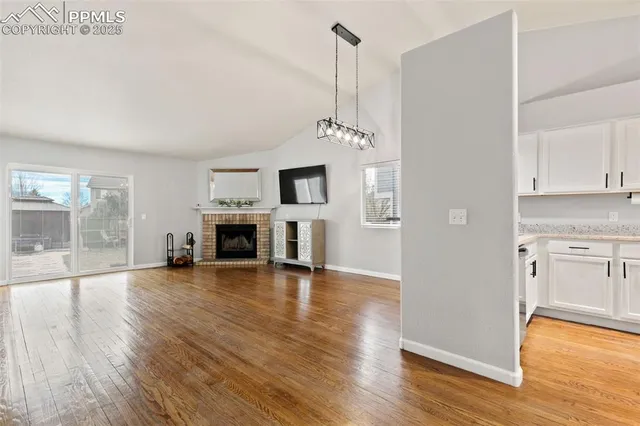 a view of empty room with wooden floor and fireplace