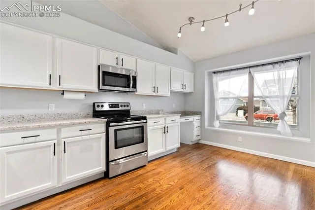 a kitchen with stainless steel appliances granite countertop a stove a sink and a microwave
