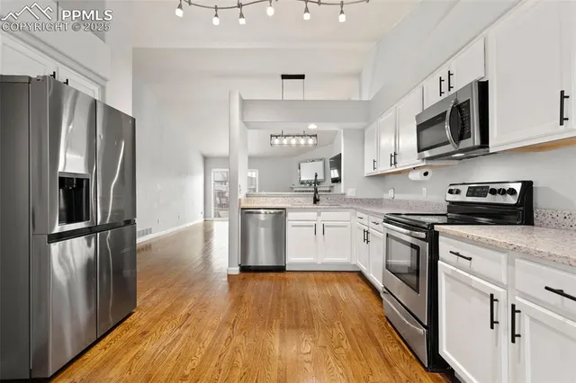 a kitchen with stainless steel appliances a refrigerator sink and microwave