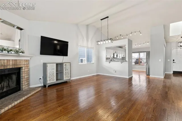 a view of a livingroom with wooden floor and a fireplace