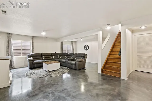 a living room with furniture and stairs
