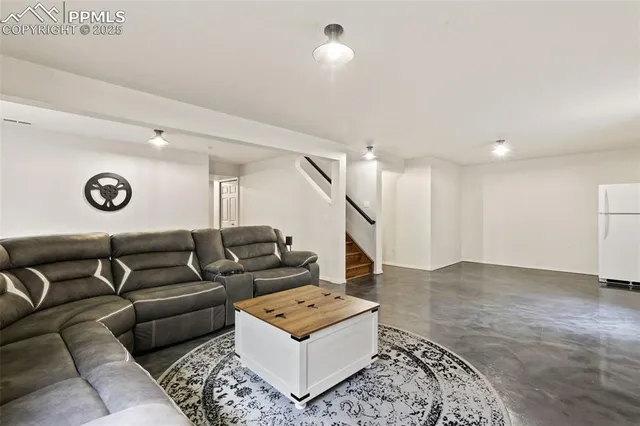 a living room with furniture and a ceiling fan