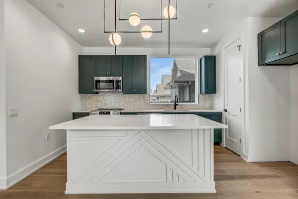 a kitchen with kitchen island a sink stainless steel appliances and cabinets
