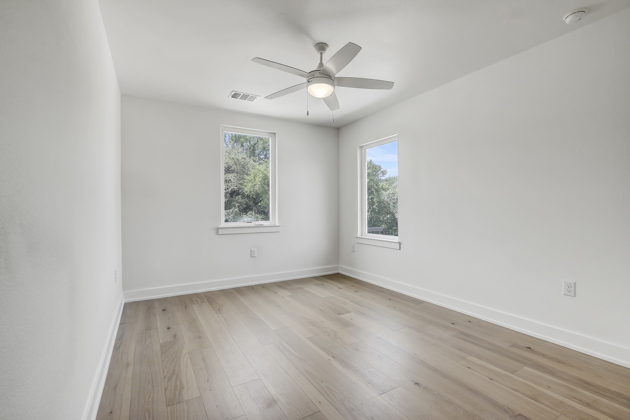 4127 East 12th Street, Unit 1 Austin, TX 78721 - Photo 19 of 30 an empty room with wooden floor chandelier fan and windows