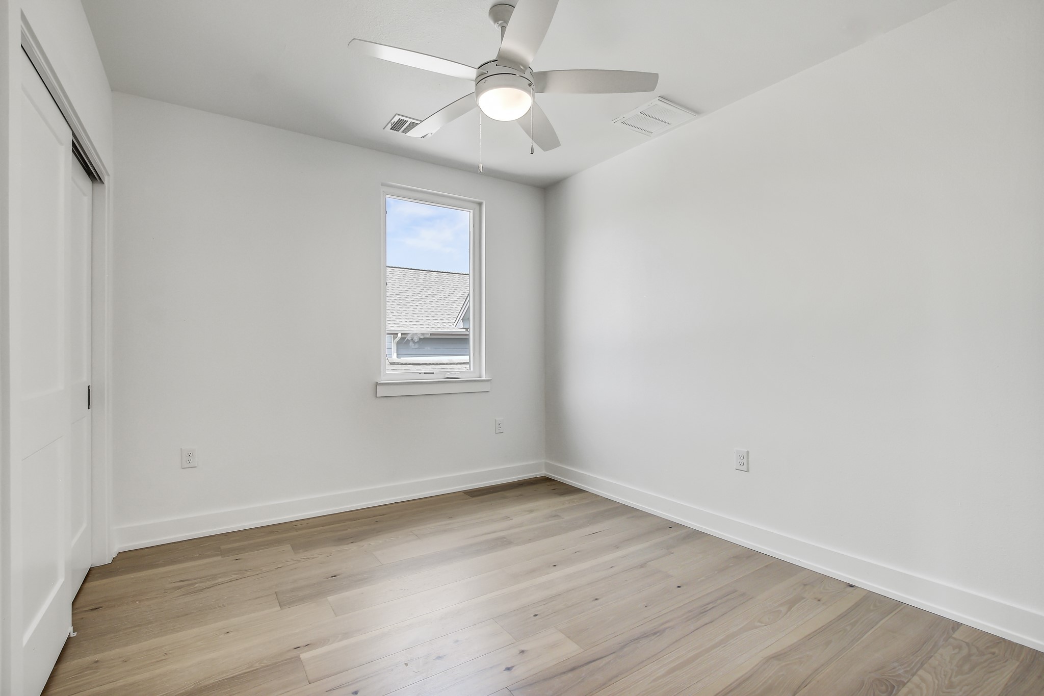 4127 East 12th Street, Unit 1 Austin, TX 78721 - Photo 24 of 30 an empty room with wooden floor fan and windows