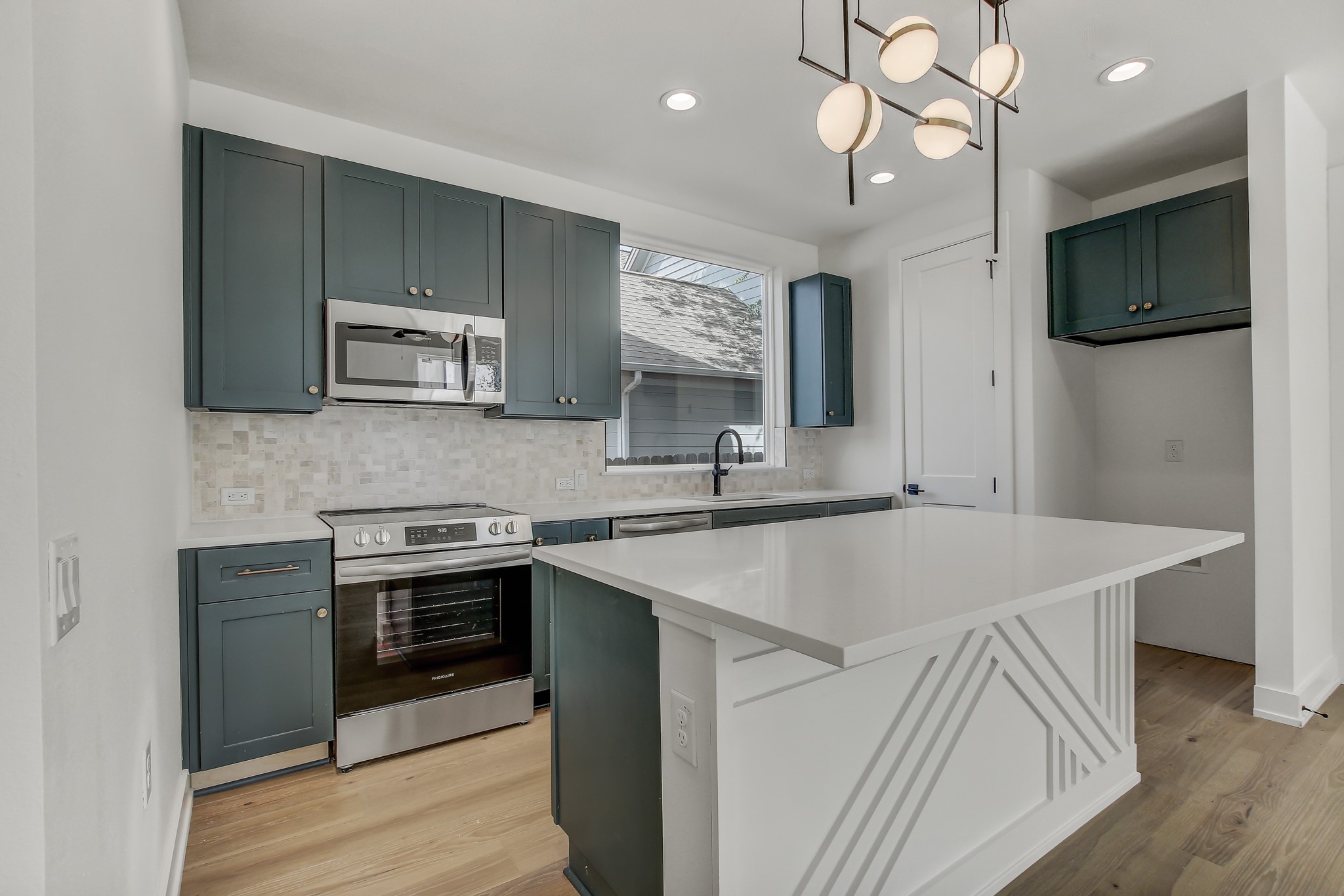 4127 East 12th Street, Unit 1 Austin, TX 78721 - Photo 3 of 30 a kitchen with kitchen island a sink stainless steel appliances and cabinets