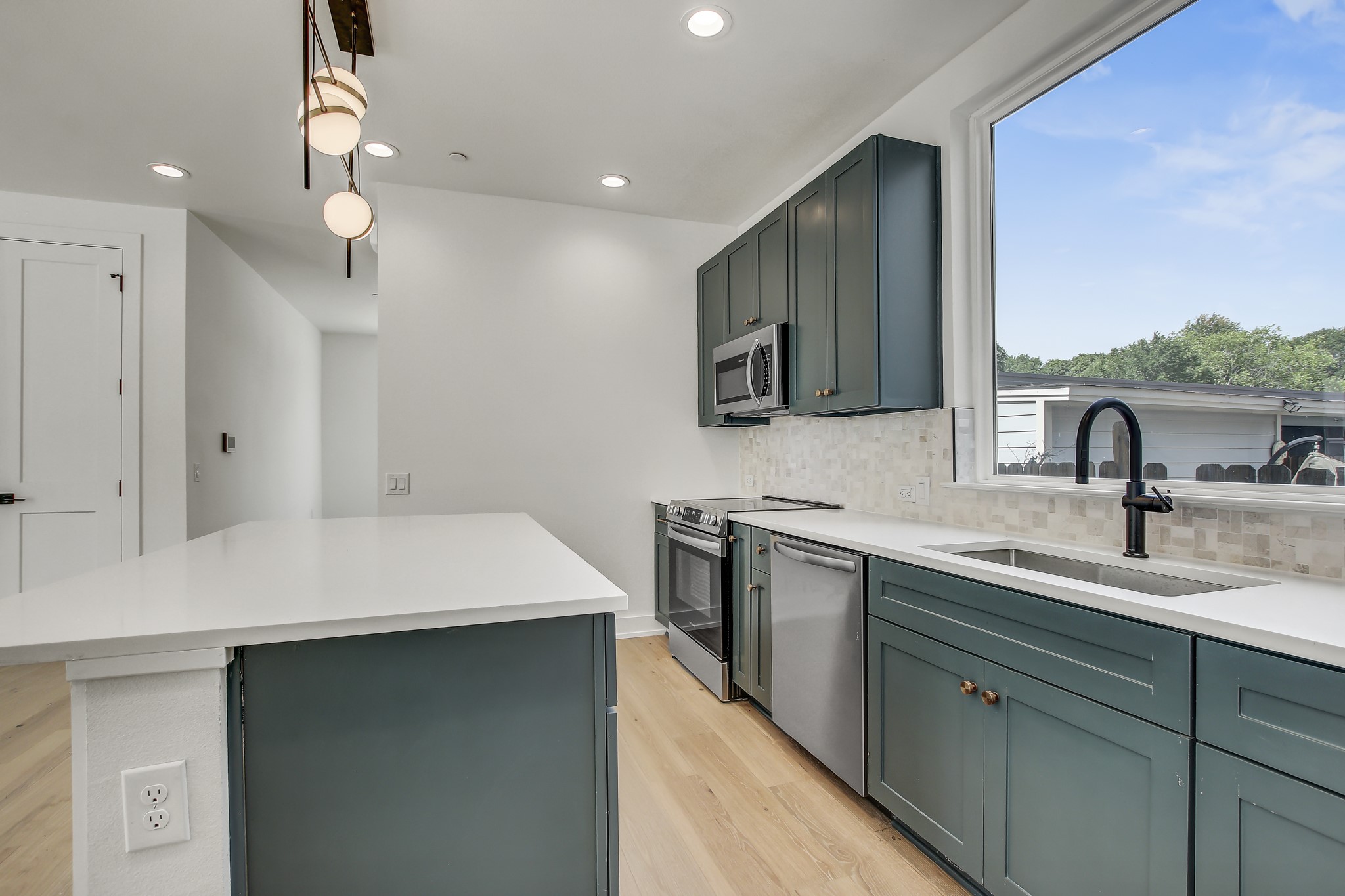 4127 East 12th Street, Unit 1 Austin, TX 78721 - Photo 4 of 30 a kitchen with a sink a stove and cabinets