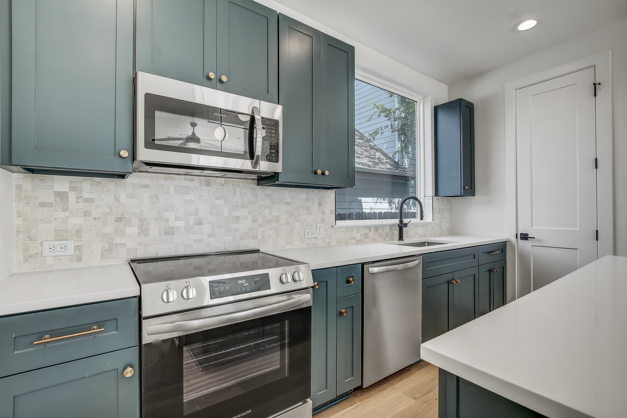 4127 East 12th Street, Unit 1 Austin, TX 78721 - Photo 5 of 30 a kitchen with a stove microwave and sink