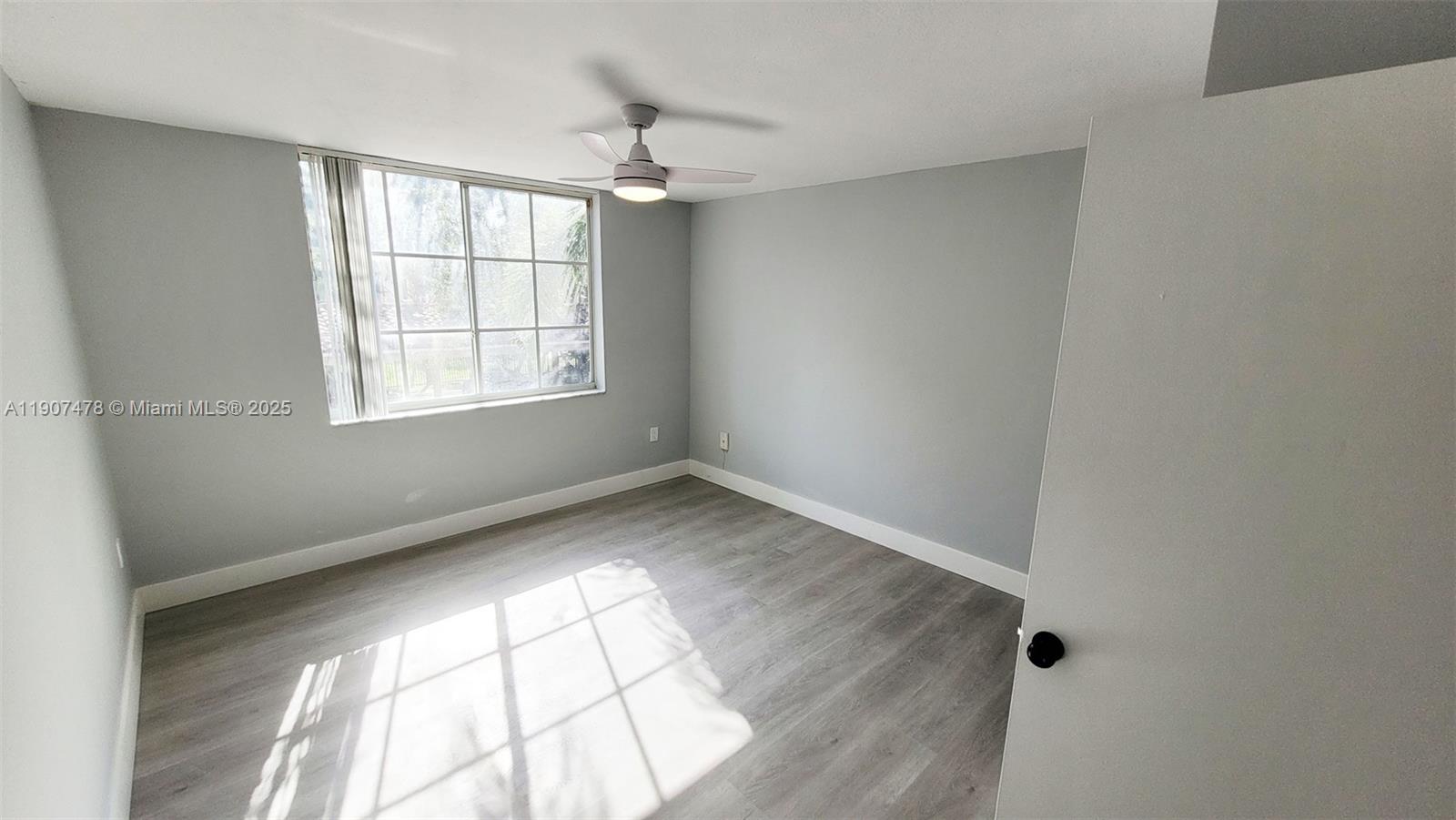 12124 St Andrews Place, Unit 203 Miramar, FL 33025 - Photo 13 of 29 an empty room with wooden floor chandelier and windows