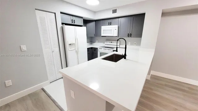 a kitchen with refrigerator and cabinets