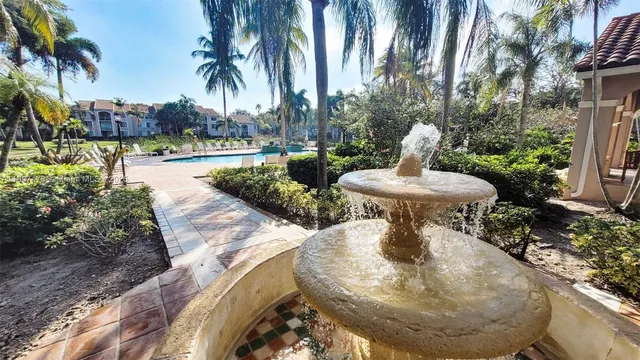 a view of a swimming pool with a fountain and plants