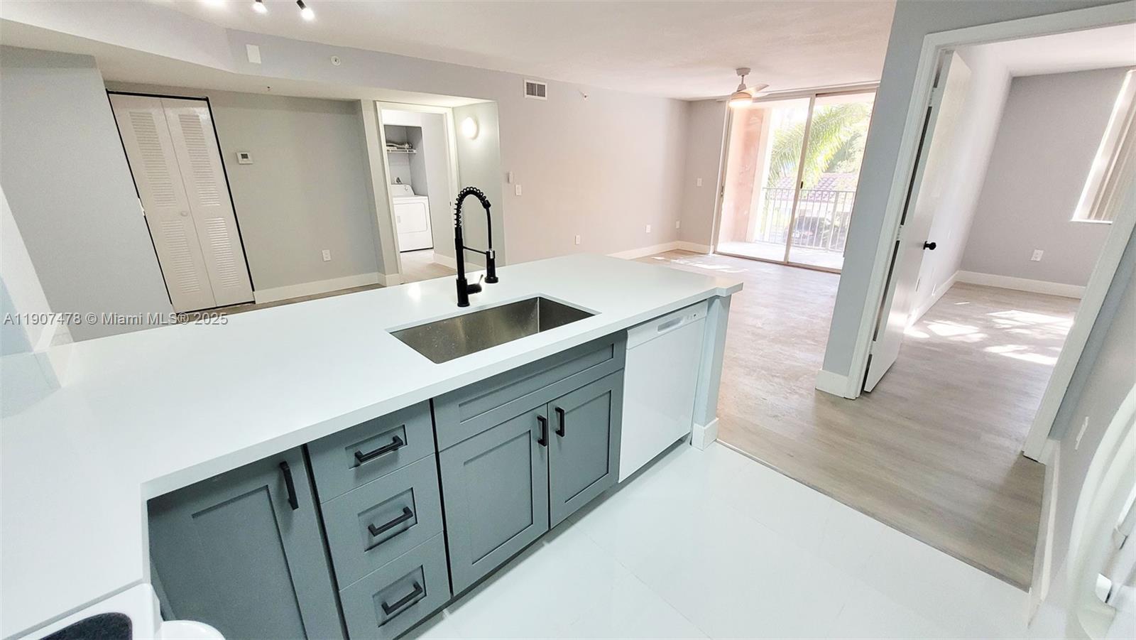 12124 St Andrews Place, Unit 203 Miramar, FL 33025 - Photo 5 of 29 a kitchen with granite countertop a sink and a large mirror