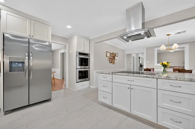 a kitchen with granite countertop white cabinets and white appliances
