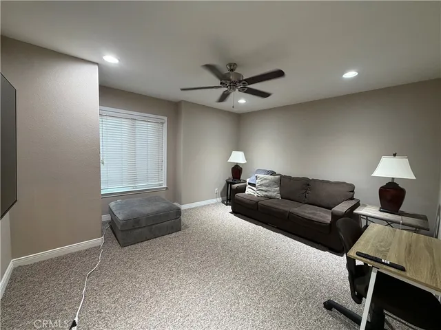 a living room with furniture and a ceiling fan