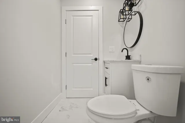 a bathroom with a toilet a sink and a mirror