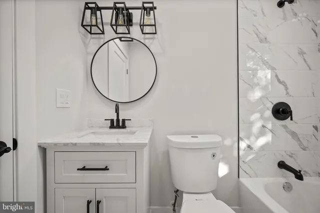 a bathroom with a sink a toilet and a mirror