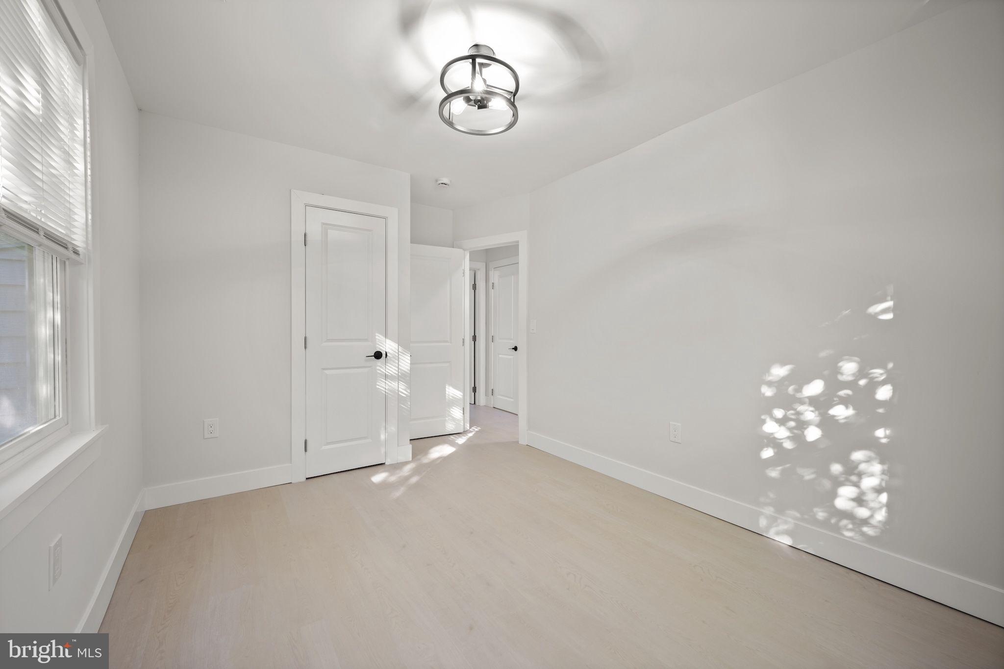 821 South Woodlynn Road Baltimore, MD 21221 - Photo 15 of 32 a view of an empty room with chandelier fan and wooden floor