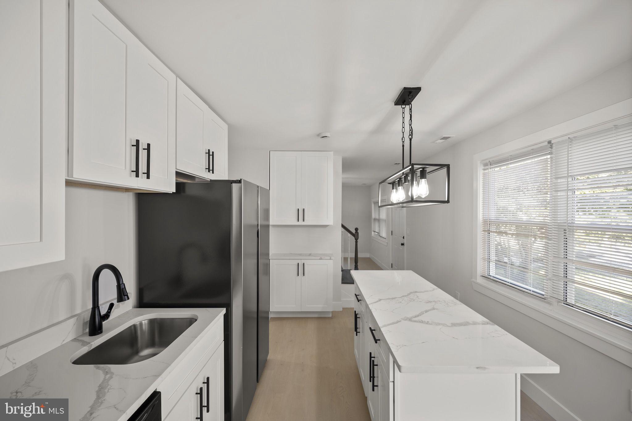 821 South Woodlynn Road Baltimore, MD 21221 - Photo 7 of 32 a kitchen with a sink a refrigerator and cabinets