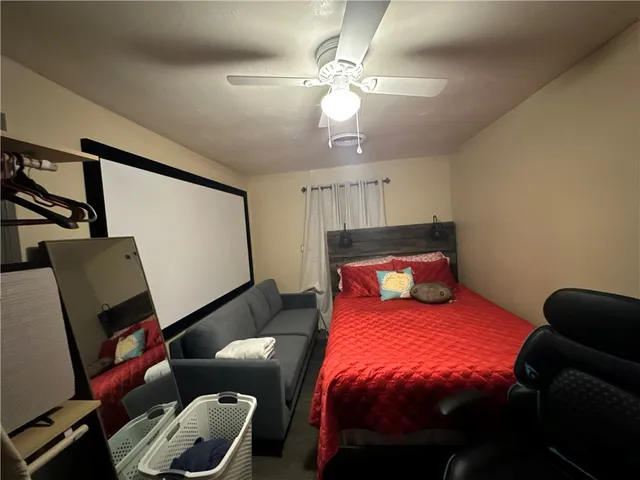 a bedroom with a bed a couch and a chandelier