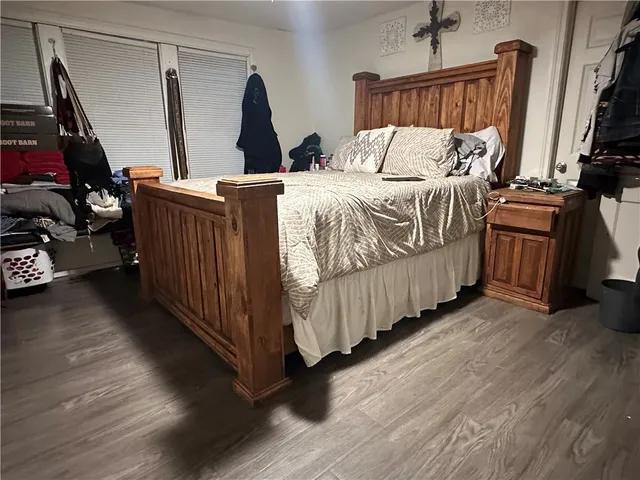 a bedroom with bed and wooden floor