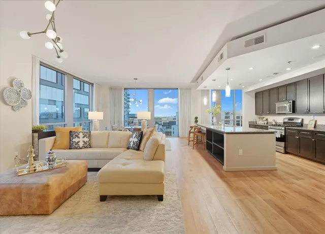 a large living room with stainless steel appliances kitchen island granite countertop furniture and a kitchen view