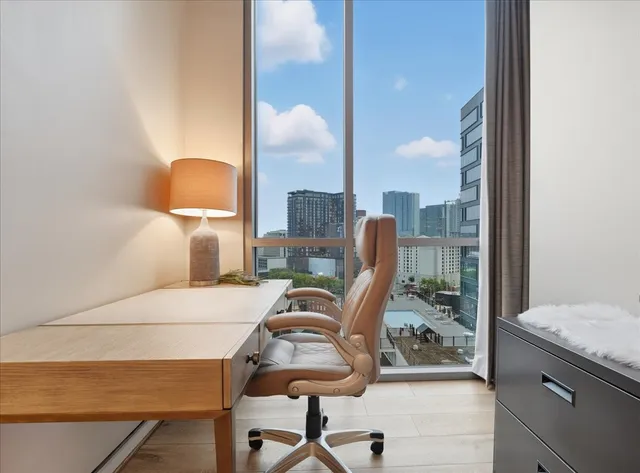 a view of a workspace with furniture and a window