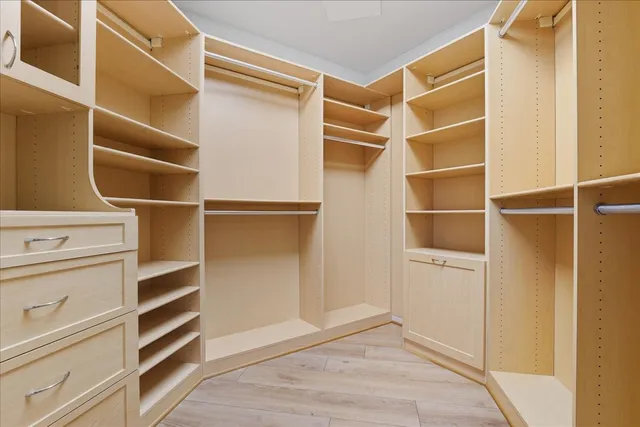 a view of walk in closet with empty racks