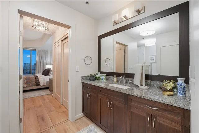 a en suite bathroom with a granite countertop sink and a mirror