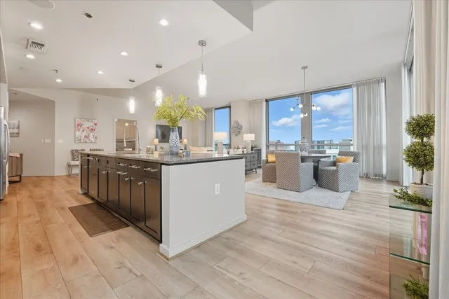a large white kitchen with kitchen island a sink a center island and stainless steel appliances