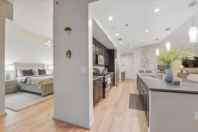 a large kitchen with stainless steel appliances kitchen island granite countertop a large counter top a refrigerator and a sink