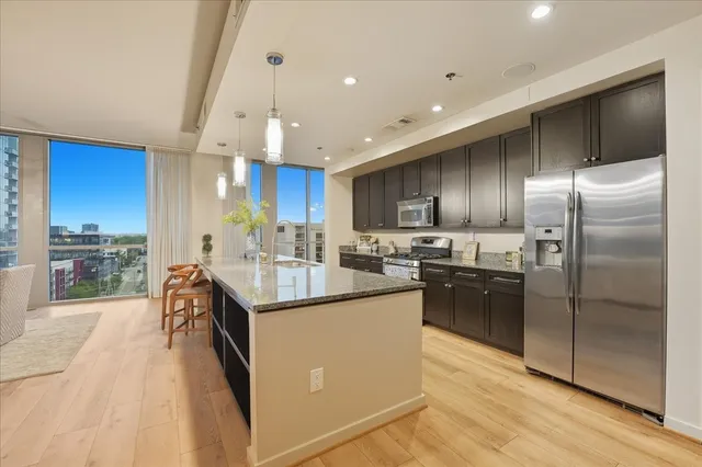 a kitchen with stainless steel appliances granite countertop a sink a stove and a refrigerator
