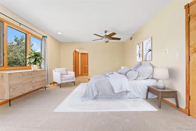 a bedroom with a bed and a large window