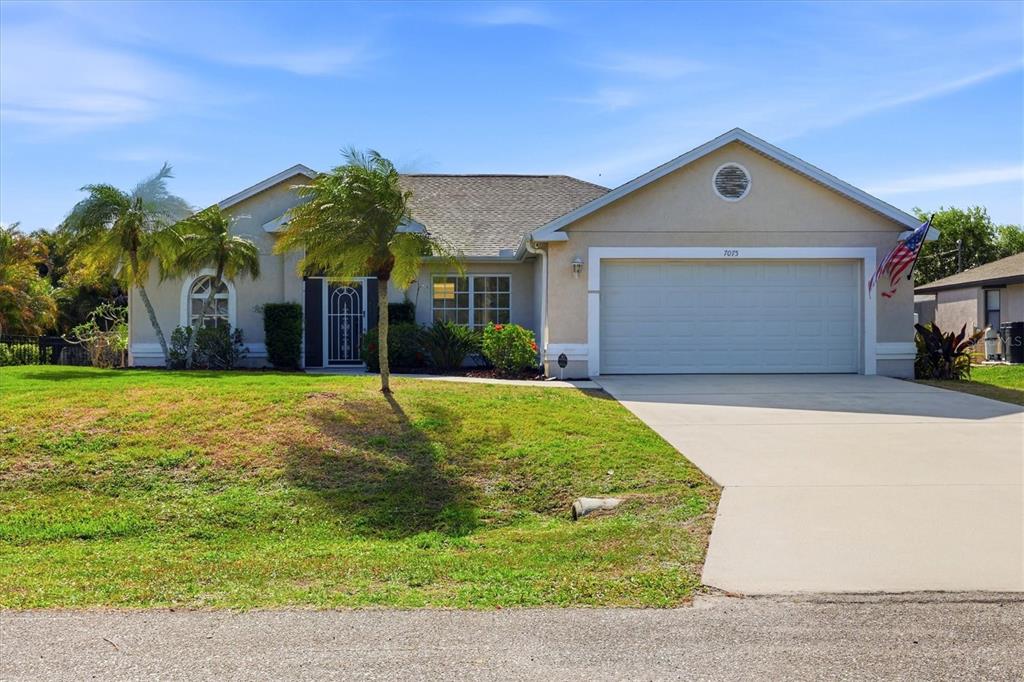 7075 Mifflin Street Englewood, FL 34224 - Photo 1 of 1 a view of a white house with a yard and palm trees