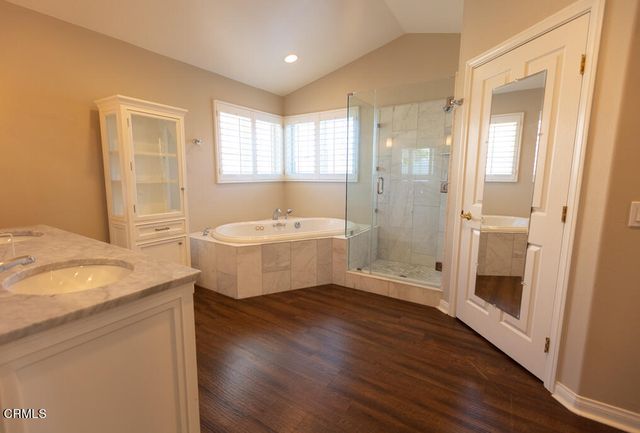 a bathroom with a granite countertop sink mirror bathtub and shower