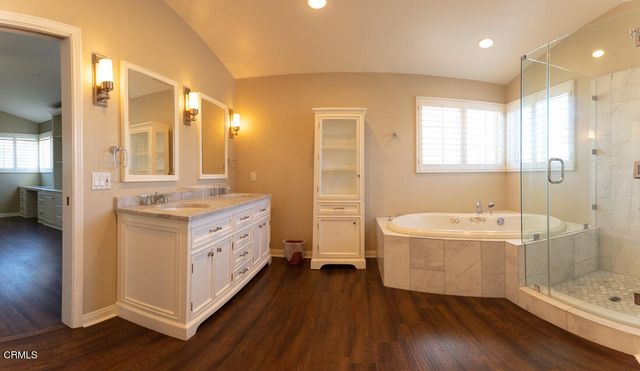 a bathroom with a double vanity sink a mirror and a bathtub