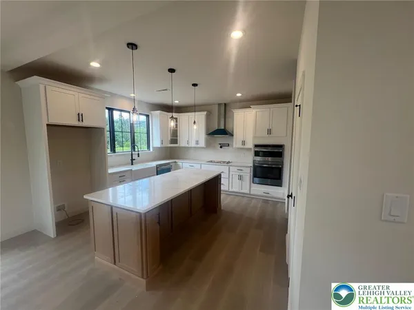 a large kitchen with stainless steel appliances a large counter top a stove a refrigerator and a sink