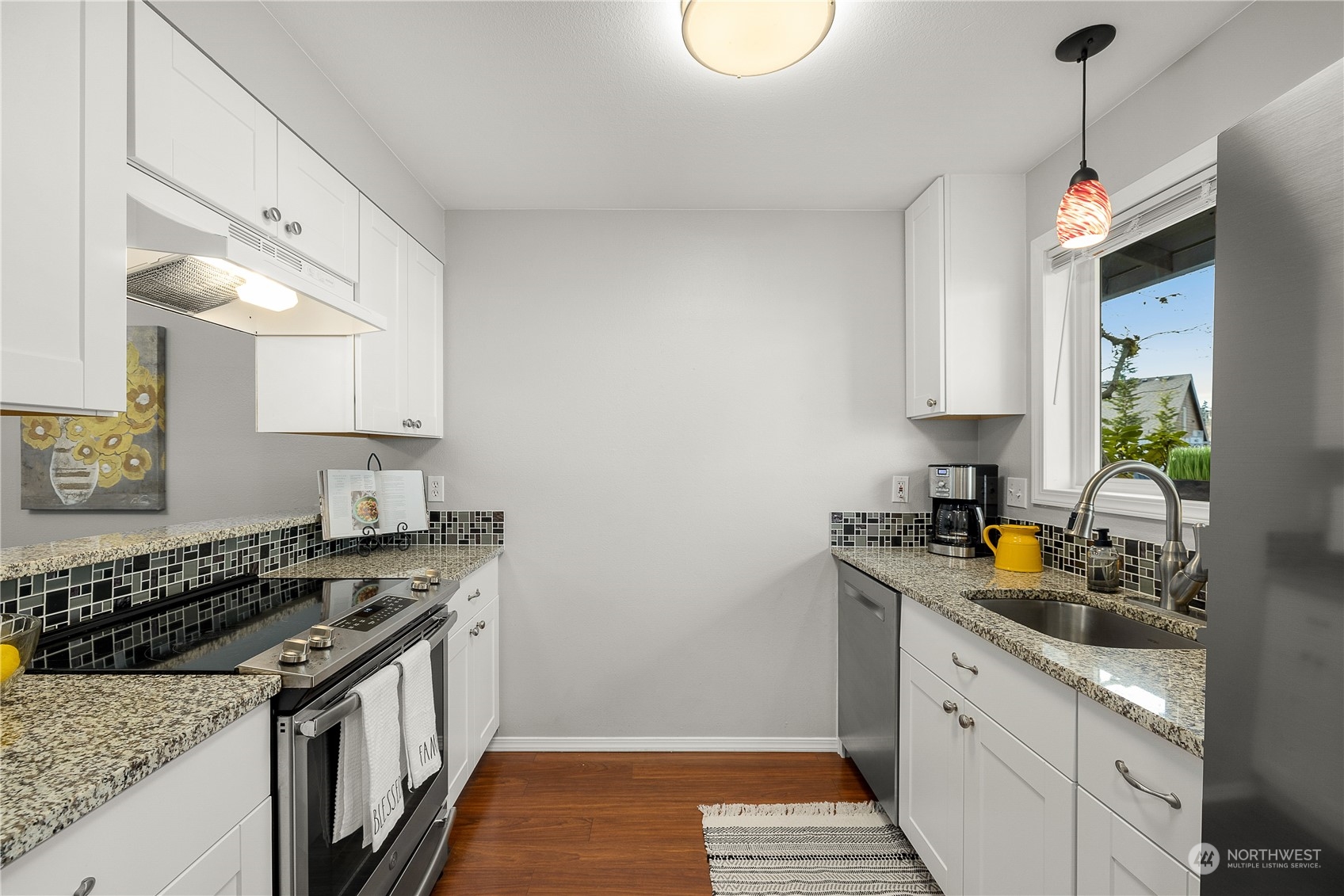 1526 192nd Street Southeast, Unit S2 Bothell, WA 98012 - Photo 4 of 16 a kitchen with stainless steel appliances granite countertop a sink stove and cabinets