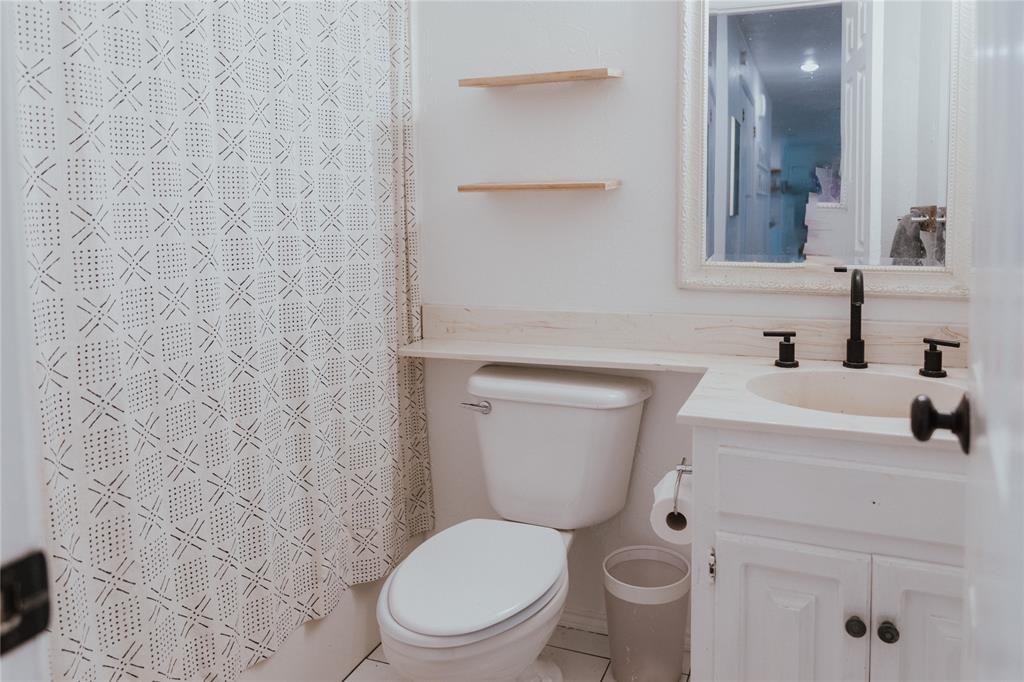 312 Perkins Road Krugerville, TX 76227 - Photo 22 of 32 a bathroom with a toilet a sink and mirror