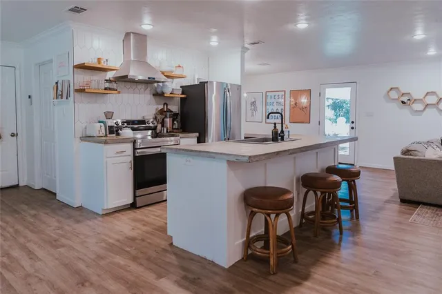 a kitchen with stainless steel appliances a refrigerator and wooden floor